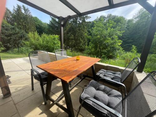 a wooden table and chairs on a patio at Bungalows am Waldessaum bei Hohenzieritz in Hohenzieritz
