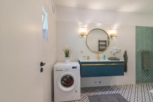 a bathroom with a washing machine and a sink at Casa felix in Loulé