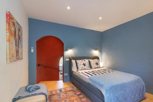 a bedroom with a bed and a blue wall at Casa felix in Loulé