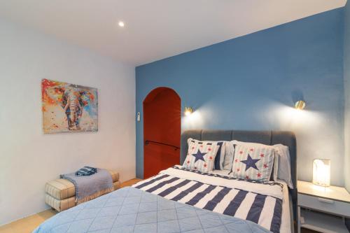 a bedroom with a bed with a blue wall at Casa felix in Loulé