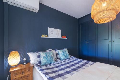 a bedroom with blue walls and a bed with pillows at Casa felix in Loulé