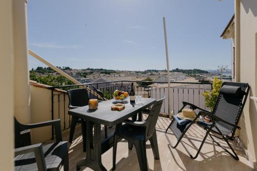 a table and chairs on a balcony with a view at Catherine's View in Agios Rokkos