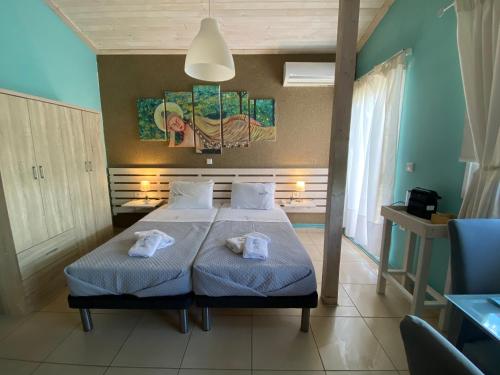 a bedroom with a bed with two towels on it at Lazy Lizard in Néa Karváli