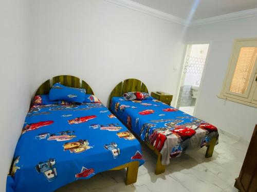 a bedroom with two beds with cars themed sheets at قريه شاطئ الشروق in Dawwār Ḩalīs