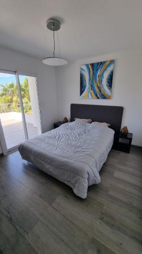 une chambre avec un grand lit dans une pièce dans l'établissement Villa Vellutini, à Calvi