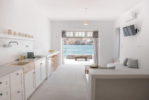 a white kitchen with a view of the ocean at Thavma Boathouse in Firopótamos