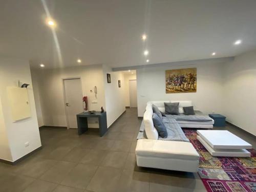 un salon avec un canapé blanc et une table dans l'établissement Appartement belle vue sur les montagnes, à Saint Pierre en Faucigny