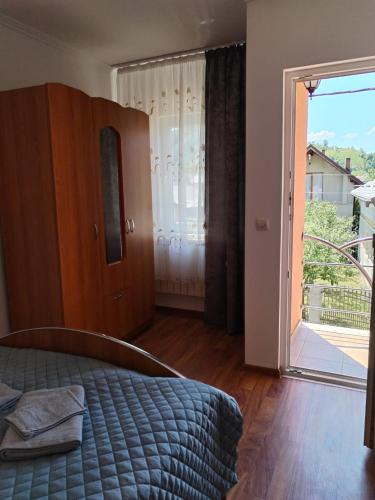 a bedroom with a bed and a sliding glass door at Casa Emma in Vişeu de Jos
