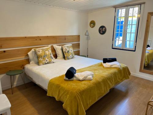 ein Schlafzimmer mit einem Bett, auf dem ein Hut liegt in der Unterkunft Vacas Felizes Villas in Ribeira Grande