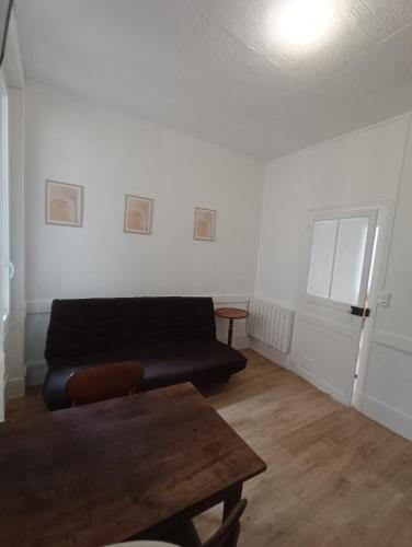 un salon avec un canapé et une table dans l'établissement Le romalie, à Vichy