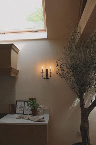 a room with a tree and candles on the wall at Stock Barn in Youlgreave