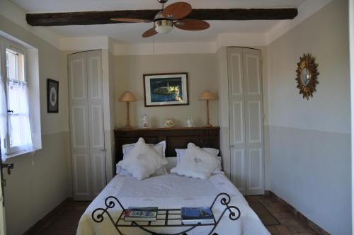 een slaapkamer met een bed en een plafondventilator bij Bastide de l'Avelan in Grimaud