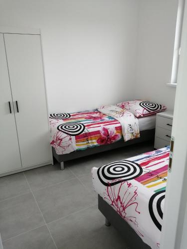 two twin beds in a room with white walls at Domki Arcadia in Gąski
