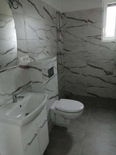 a bathroom with a white toilet and a sink at Domki Arcadia in Gąski