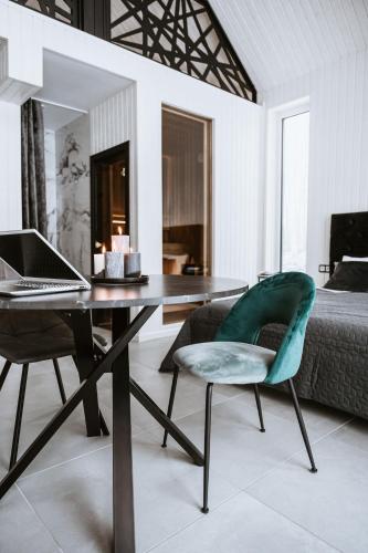 a bedroom with a desk with a laptop and a chair at Sniegi design cabin with included sauna and jacuzzi in Madona
