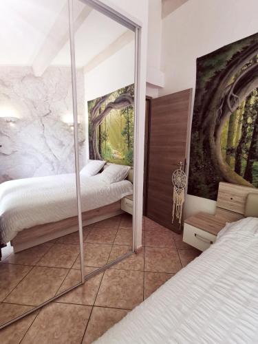 a bedroom with two beds and a mirror at Maison de Charme en couleurs in Cuers