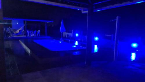 ein dunkles Zimmer mit einem Pool mit blauen Lichtern in der Unterkunft HOTEL FAZENDA BOLANDEIRA in Conde