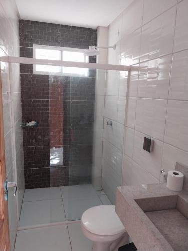 uma casa de banho com um chuveiro, um WC e um lavatório. em Casa Pitanga em Olinda