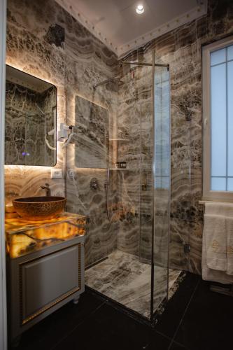 a bathroom with a glass shower and a sink at Ervini Boutique Hotel in Shkodër