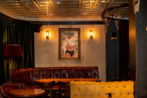 a restaurant with tables and chairs and a painting on the wall at Hotel B Berdichevsky in Tel Aviv