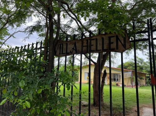 a sign on a fence in front of a house at Cabaña Villa Hellen in Santa Marta