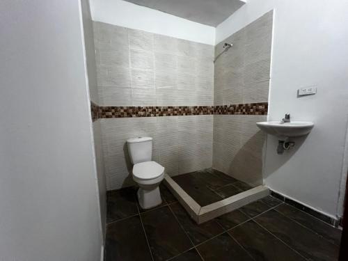 a bathroom with a toilet and a sink at Cabaña Villa Hellen in Santa Marta