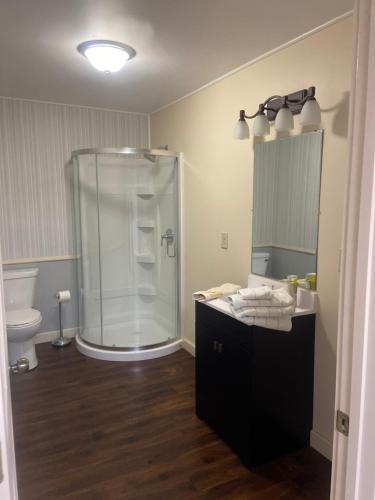 a bathroom with a glass shower and a sink at Best value 4 Huge Bedrooms in Willmar