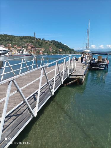 a wooden bridge over the water with a boat at "A Ridosso" sul mare nel cuore del paese in Le Grazie