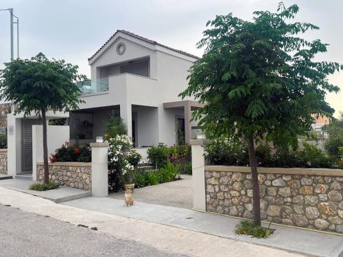 a house with a cat sitting in front of it at Easy Living 1 & 2 in Kos Town