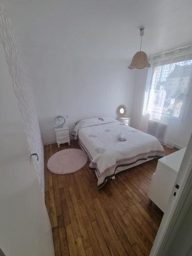a bedroom with a bed and a wooden floor at Evene's home in Ploërmel