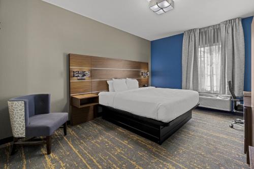 um quarto de hotel com uma cama e uma cadeira em The Mulberry Hotel em Westlake