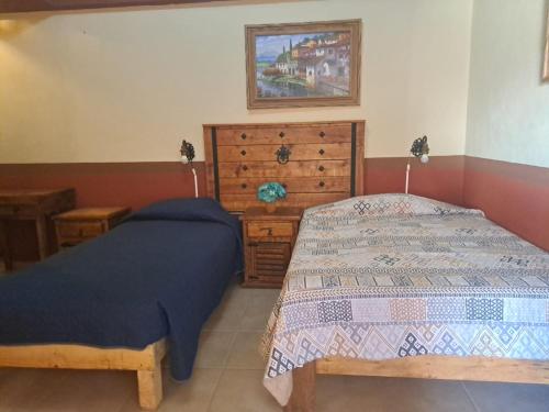 a bedroom with two beds and a dresser at Hotel Hacienda San José in San Francisco del Rincón