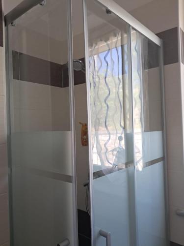 a glass shower door with a curtain in a bathroom at Casa Balda in Imperia