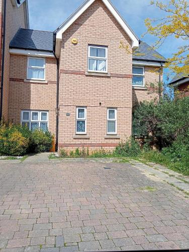 a brick house with windows and a brick driveway at Ocean-homestay in Colchester