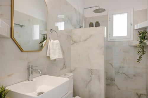 a white bathroom with a sink and a shower at Vivian Apartments in Vlachata