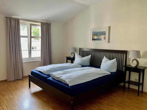 a bedroom with a bed with blue sheets and a window at Alte Buchdruckerei in Heringsdorf