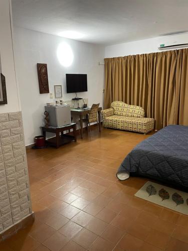 - une chambre avec un lit et un bureau avec une télévision dans l'établissement Villa Mango, à Abidjan