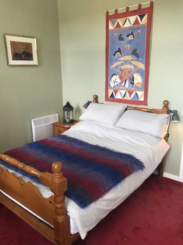 a bedroom with a bed with a colorful blanket on it at Tay View in Perth