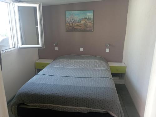 a bed in a small room with a mirror at Gîte à la ferme in Laudun