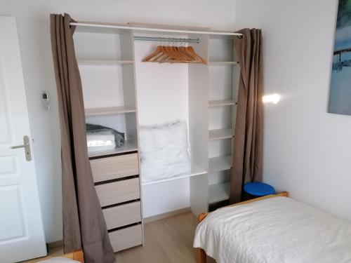 - une chambre avec un lit et un placard dans l'établissement Maison Palmier du lac, à Port-la-Nouvelle