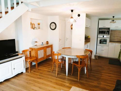 une cuisine et une salle à manger avec une table et des chaises dans l'établissement Maison Palmier du lac, à Port-la-Nouvelle