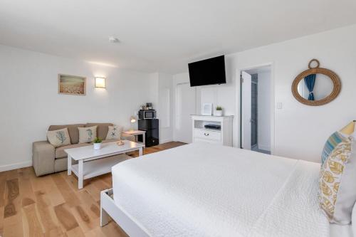 a white bedroom with a white bed and a couch at The Ocean Resort Inn in Montauk