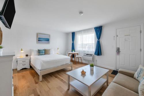 a bedroom with a bed and a couch and a table at The Ocean Resort Inn in Montauk