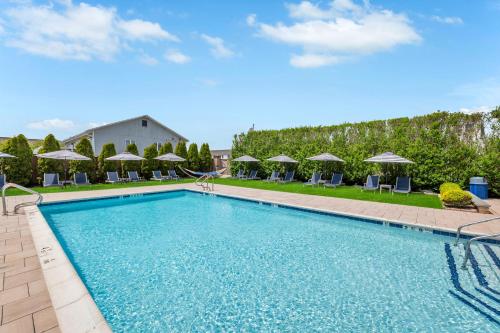 a swimming pool with chairs and umbrellas at The Ocean Resort Inn in Montauk