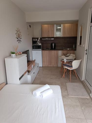 a white kitchen with a white bed and a table at Megi Apartments, Nesebar sity in Nesebar