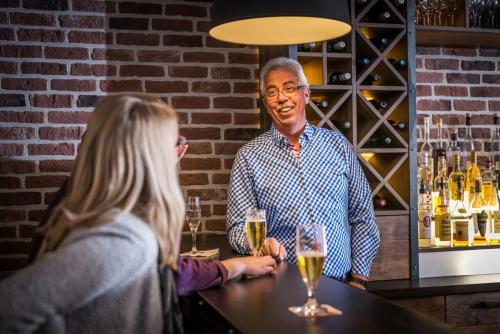 a man standing at a bar with a woman at Stratmanns Hotel in Lohne
