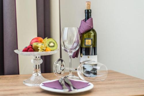 a bottle of wine and a plate of fruit on a table at Stratmanns Hotel in Lohne