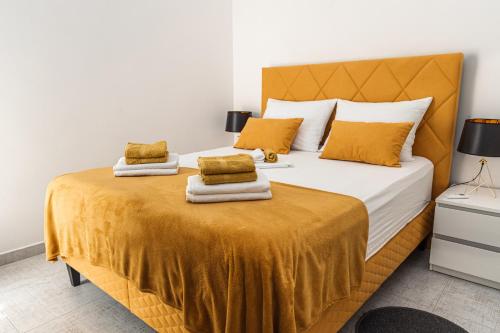 1 dormitorio con 1 cama grande con almohadas amarillas en Carpe Diem***, en Lun