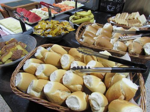 a buffet of food with baskets of bread and fruit at Hotel Paramount - São Paulo - Próximo a 25 de Março, Brás e Bom Retiro "Garanta já sua hospedagem" in Sao Paulo