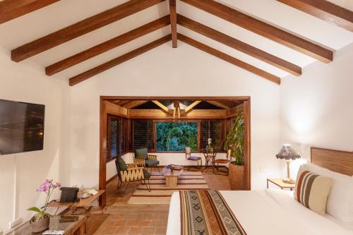 a bedroom with a bed and a living room at Sazagua Hotel Boutique in Pereira